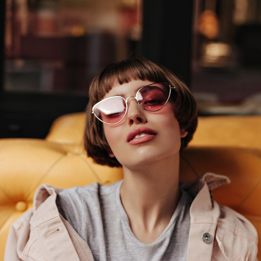 Cô gái cá tính đang đeo kính mát mắt mèo tròng hồng viền kim loại